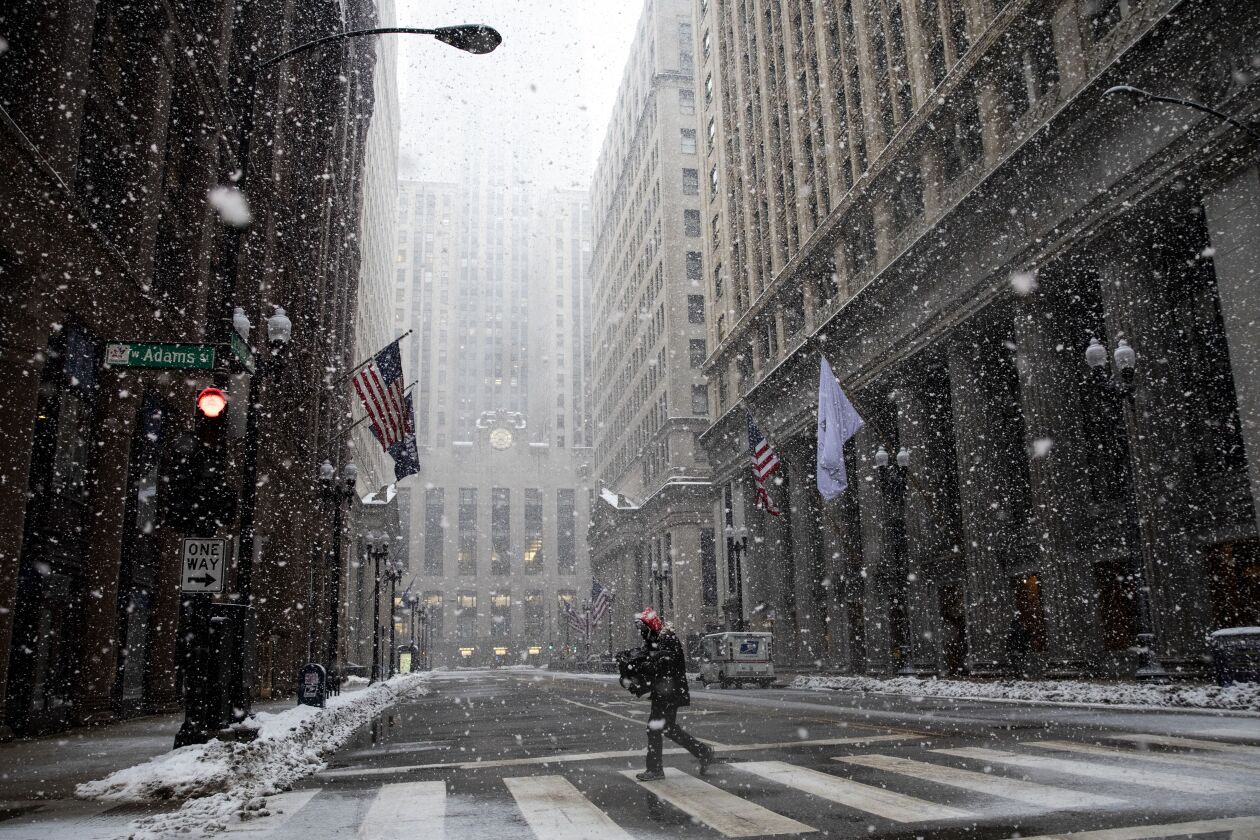 A person crosses LaSalle Street in the Loop as snow falls across Chicago, Thursday afternoon, Feb. 4, 2021.